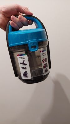 Osoba trzymająca pojemnik na kurz z odkurzacza.