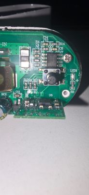 Close-up of PCB with push button, capacitors, and electronic chips