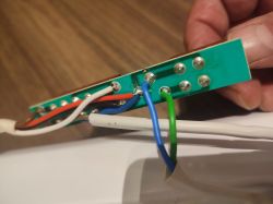 Zbliżenie na zieloną płytkę PCB z przylutowanymi kolorowymi przewodami