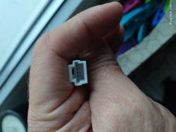 Biała wtyczka elektryczna w dłoni – zbliżenie Zbliżenie na białą wtyczkę elektryczną trzymaną w dłoni, z widocznymi metalowymi stykami.
