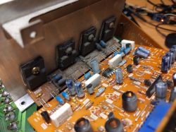 Zbliżenie na płytkę wzmacniacza audio z widocznymi komponentami elektronicznymi.