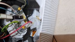 Zbliżenie na przewody i element grzałki w zmywarce Bosch, widoczne ślady korozji i zabrudzeń