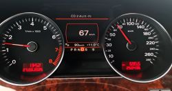 Zbliżenie na zegary samochodu Audi, na których widoczne są wskaźniki prędkości, obrotomierz, przebieg 250436 km, temperatura 11°C oraz aktualna prędkość 67 km/h.