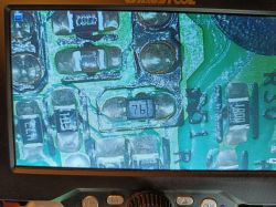 Close-up of a circuit board with components, including a marking 76 on one part.