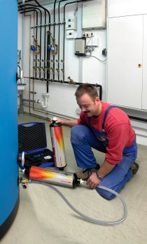 Technik montujący wkład do demineralizacji i zmiękczania wody przy kotle kondensacyjnym.