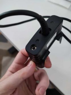 Wtyczka zasilania DC gniazda USB do skanera Honeywell 99EX trzymana w dłoni.