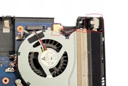 Fragment płyty laptopa z wentylatorem, radiatorem i zaznaczonym złączem z przewodem