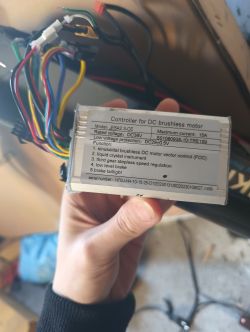 Ręka trzymająca kontroler do silnika bezszczotkowego DC z opisanymi funkcjami.