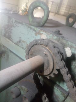 Zbliżenie na mechanizm zębatkowy z łańcuchem w maszynie przemysłowej.