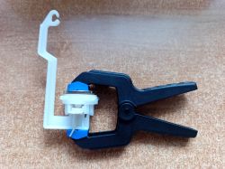 Inter-Sano Fill Valve Membrane Repair with Silicone Glue, Clamp, and Coin View of the membrane and plastic control chamber element of an Inter-Sano fill valve, with marked glue application points, spring clamp, and a 1 zł coin used for pressure distribution.