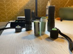 Verschiedene Taschenlampen und Zubehör auf einem Tisch, einschließlich Batterieadaptern.