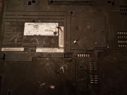 Spód laptopa IBM ThinkPad z zabrudzoną obudową i etykietą modelu; widoczne kratki wentylacyjne