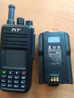 Radiotelefon TYT MD-380 oraz jego odłączona bateria na stole