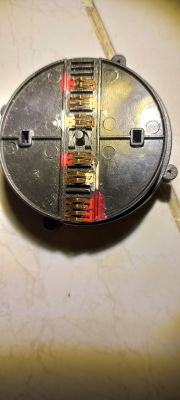 View of the back side of a multimeter's rotary switch with metal contacts.