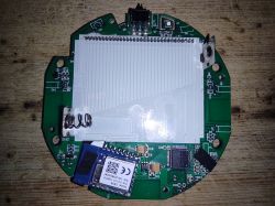 Image of a round printed circuit board with various electronic components on a wooden background.