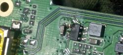 Zbliżenie na płytkę drukowaną z widocznymi ścieżkami i komponentami elektronicznymi, w tym układem oznaczonym jako ABV01.