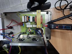 Testowanie układu zasilania myjki ultradźwiękowej InterSonic IS-3 Widok wnętrza myjki ultradźwiękowej z otwartą obudową i miernikiem podłączonym do płytki