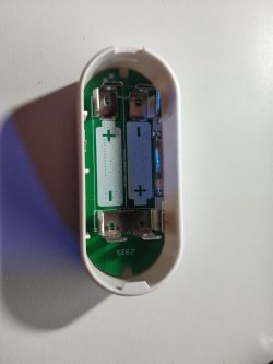 Interior of Open Door/Window Sensor Close-up of an open door/window sensor showing battery contacts and electronic components inside the casing.