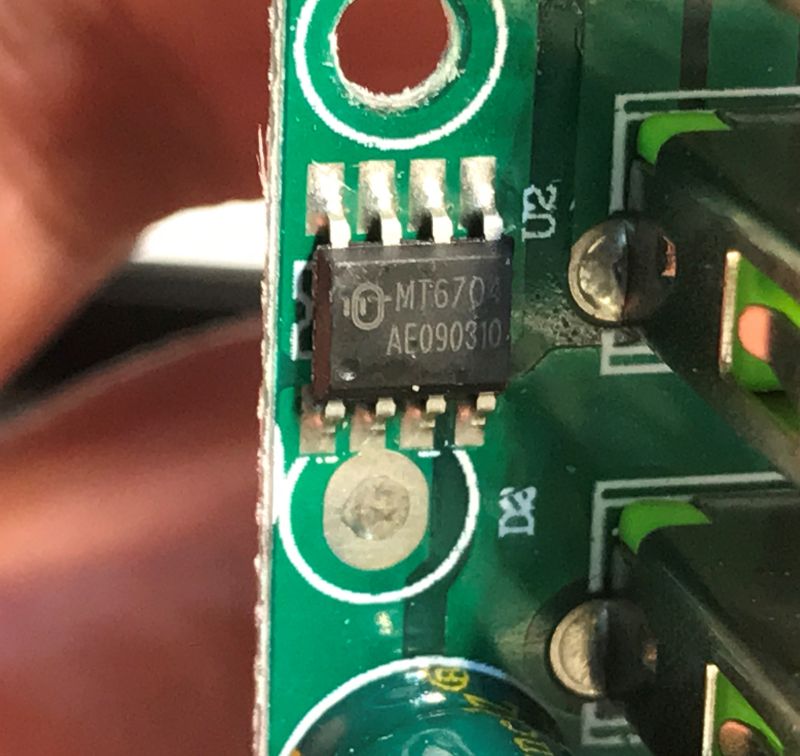 Close-up of MT6704 integrated circuit on green PCB with visible soldered pins
