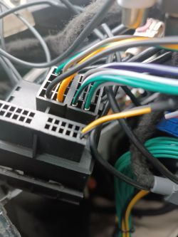 Zbliżenie na złącze ISO z podłączonymi kolorowymi przewodami w samochodzie Peugeot 3008