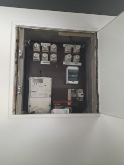 Stara skrzynka elektryczna z licznikami i topikowymi bezpiecznikami porcelanowymi