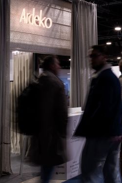 Ardeko trade show booth with curtains; blurred visitors walking in the foreground.