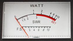 Analogowy wskaźnik z podziałką mierzącą SWR i moc w watach, z czerwoną strefą dla ustawień.