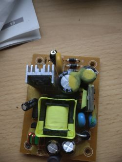 Płytka drukowana z elementami elektronicznymi na drewnianym biurku.