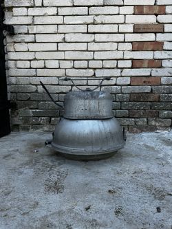 Stara lampa przemysłowa PREDOM-MESKO OURP-250 na tle ceglanej ściany.