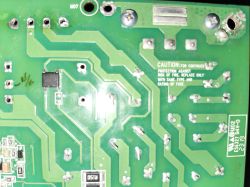 Printed circuit board with fuse warning and soldered components Green PCB with visible solder joints, circuit traces, and a fuse warning message