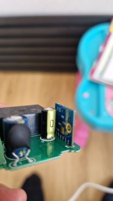 Close-up of a PCB with relay, capacitors, and a blue electronic module
