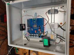 Wnętrze skrzynki elektrycznej z zamontowaną niebieską płytką PCB i wyświetlaczem pomiarowym