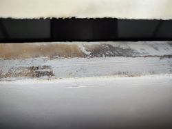 Close-up of the edge of a fireplace panel covered with mesh.