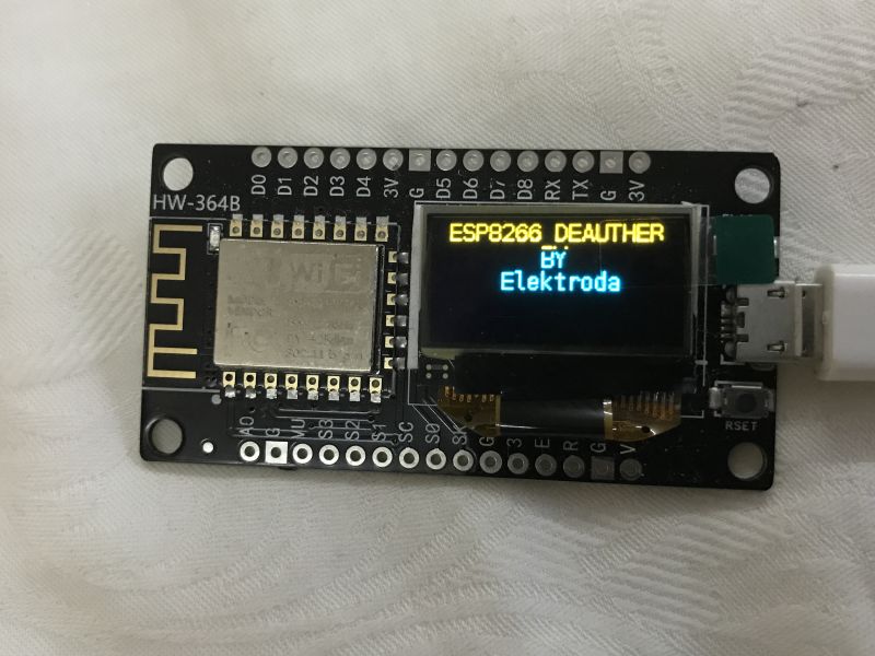 Płytka ESP8266 z małym ekranem OLED, na którym widać napis „ESP8266 DEAUTHER BY Elektroda”