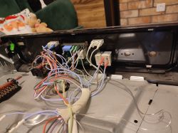 Wnętrze panelu przedniego piekarnika z widocznymi przewodami elektrycznymi i złączami.