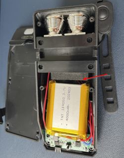 Wnętrze urządzenia z otwartą obudową ukazującą baterię litowo-jonową.