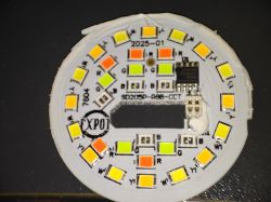 Round LED PCB with colorful LEDs and electronic chip.