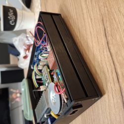 Black electronics enclosure with visible internal circuitry and wiring.