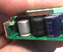 Close-up of Sonoff MINIR4M relay internals showing capacitors and PCB components