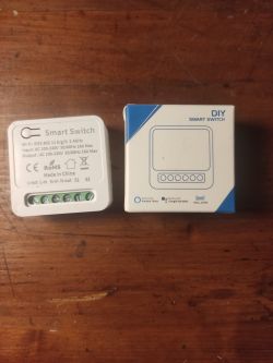 DIY smart switch device and box on a wooden surface.