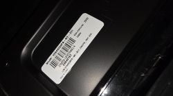 White barcode label with model number on a black glossy surface