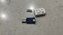 Disassembled USB Adapter on a Table Disassembled USB adapter with visible blue PCB and casing on a light-colored surface.