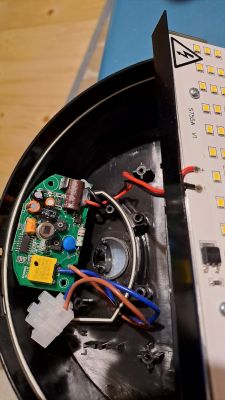 Wnętrze lampy z widoczną płytką elektroniczną i okablowaniem.