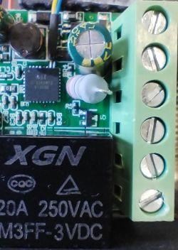 Printed circuit board with visible electronic components including an integrated circuit, capacitors, and a screw terminal.