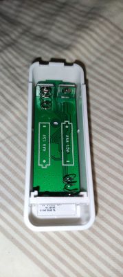 Temperature and Humidity Sensor TH01Y Case with Battery Slots Temperature and humidity sensor case without batteries on a fabric background.