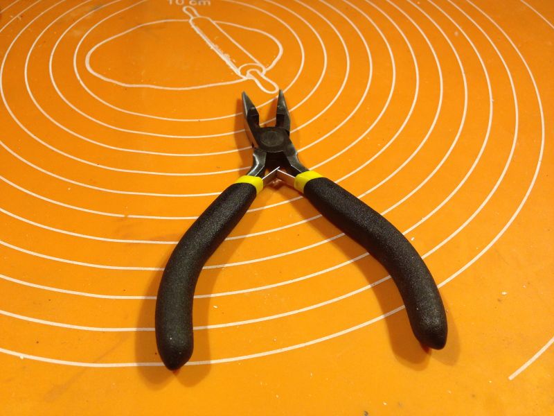 Czarne kombinerki na pomarańczowej macie z białymi okręgami