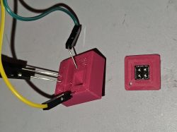 3D-Printed Chip Holder for Firmware Flashing Pink 3D-printed chip holder with connected wires and a separate chip module