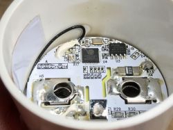 Close-up of a WiFi socket's interior showing a circuit board with a wire antenna and electronic components.