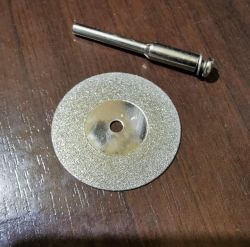 Diamond cutting disc with a diameter of 35 mm and thickness of 0.6 mm on a wooden surface.