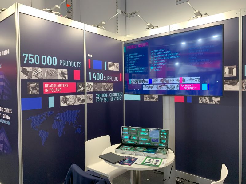 Stoisko wystawiennicze z bannerem promującym działalność TME na targach Embedded World 2024.